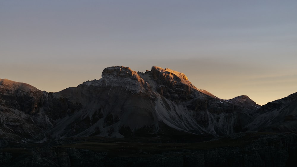the sun is setting on a mountain range