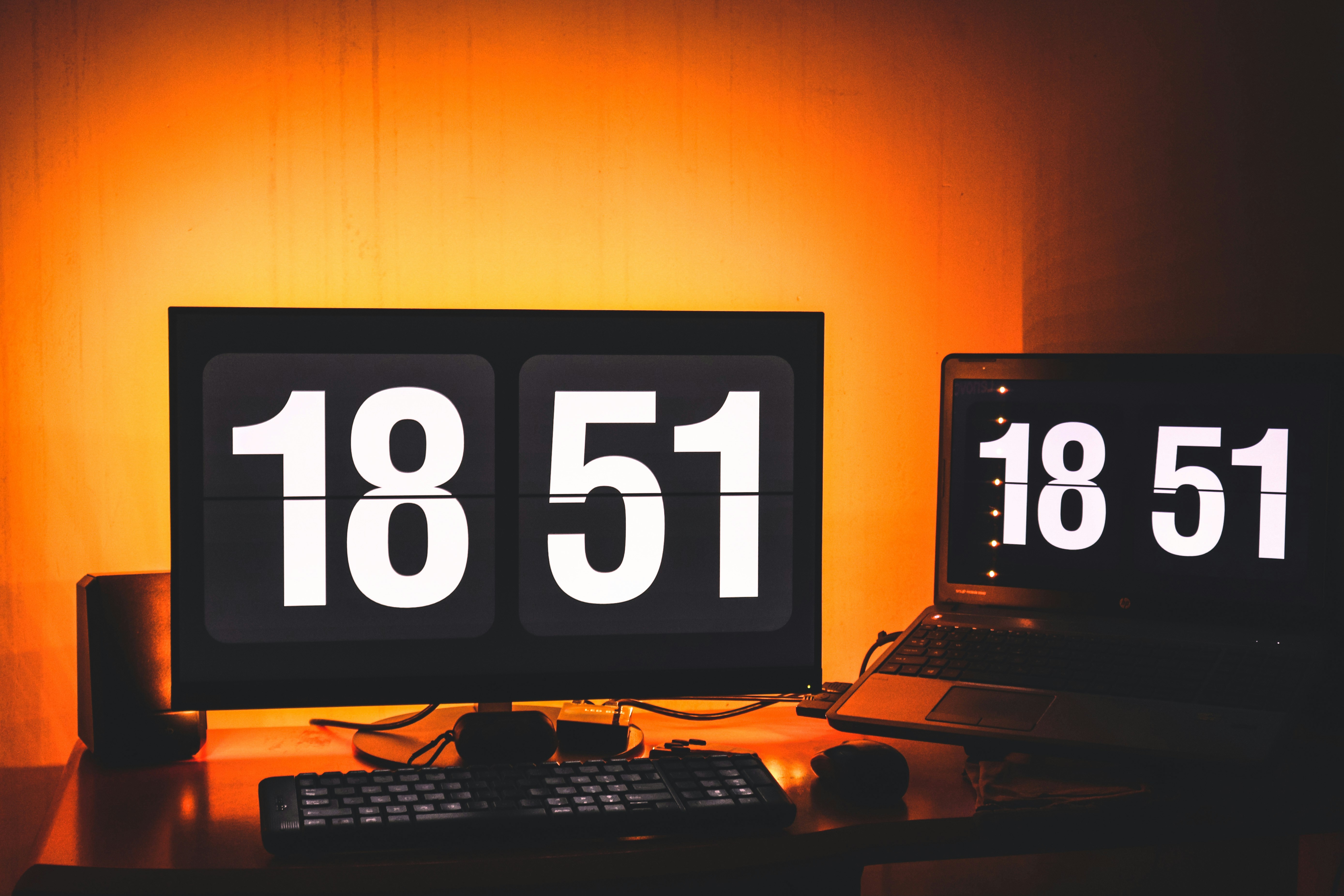 a desk with a laptop and a clock on it