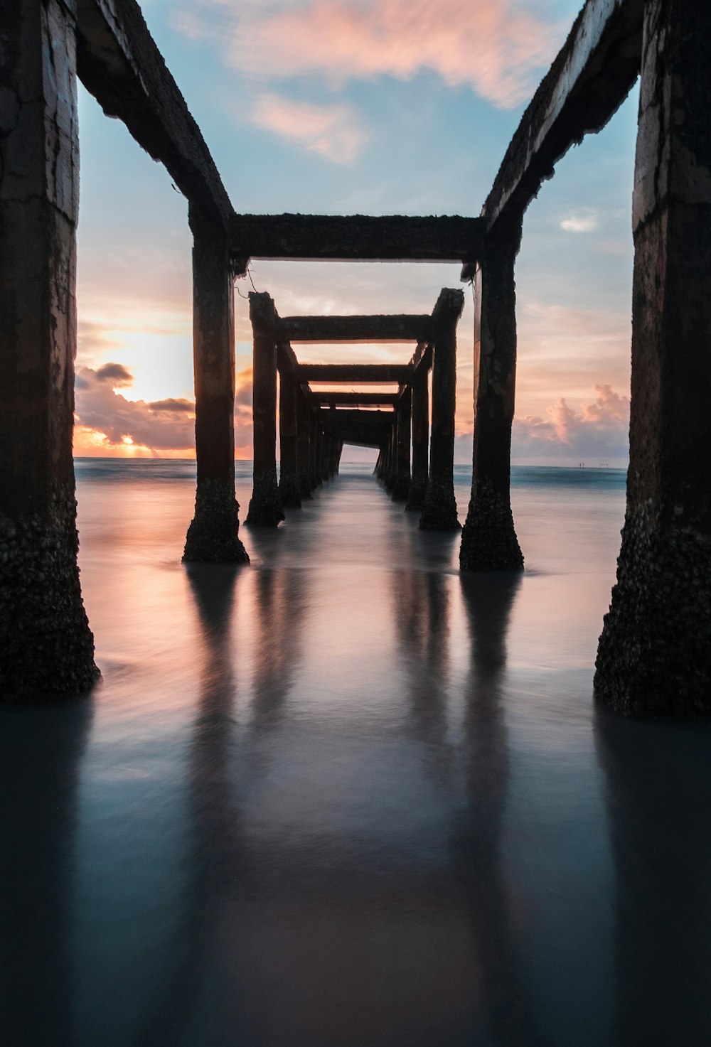a long pier stretching into the ocean at sunset