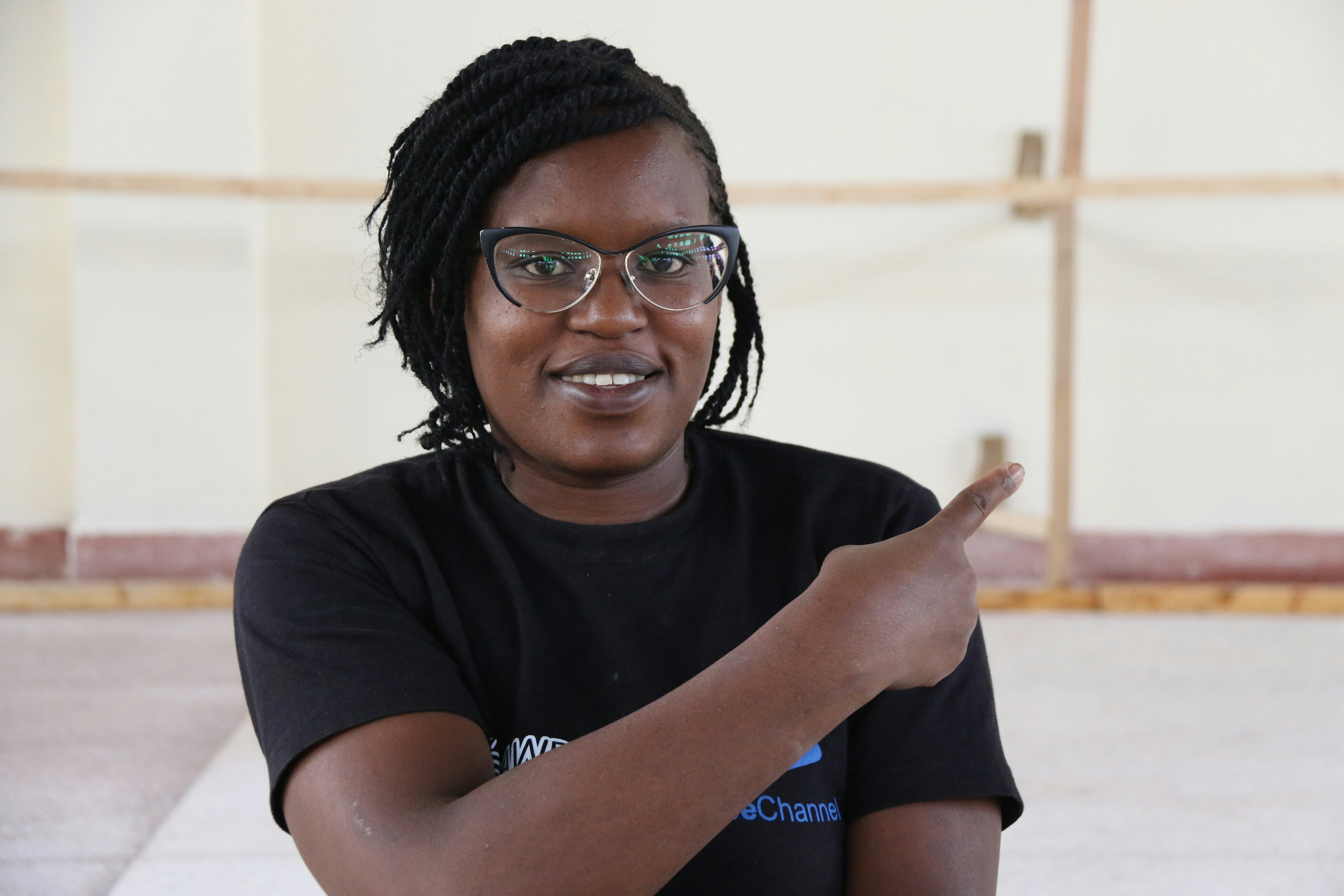 a woman wearing glasses points at something