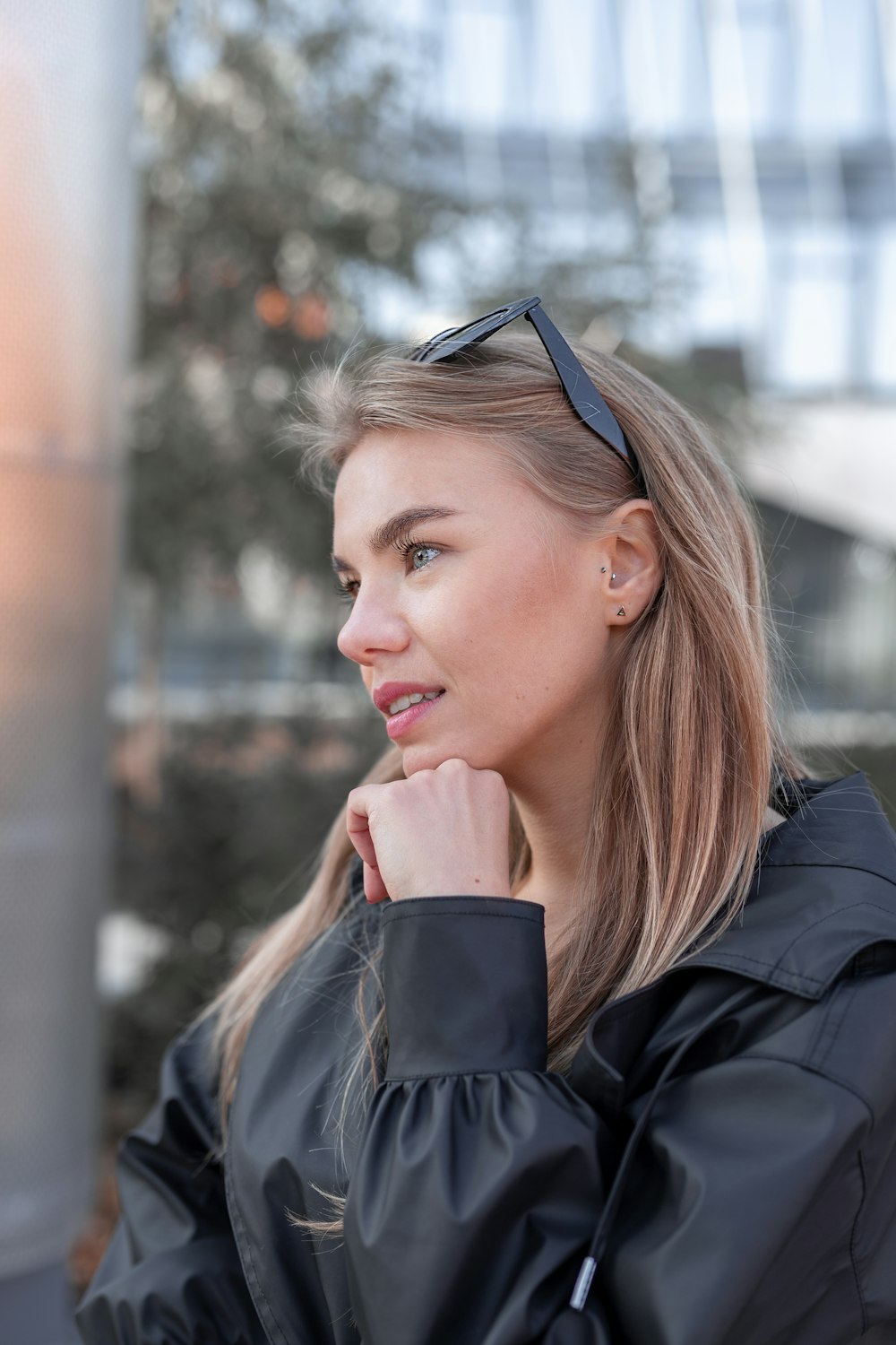 a woman wearing a black jacket and sunglasses