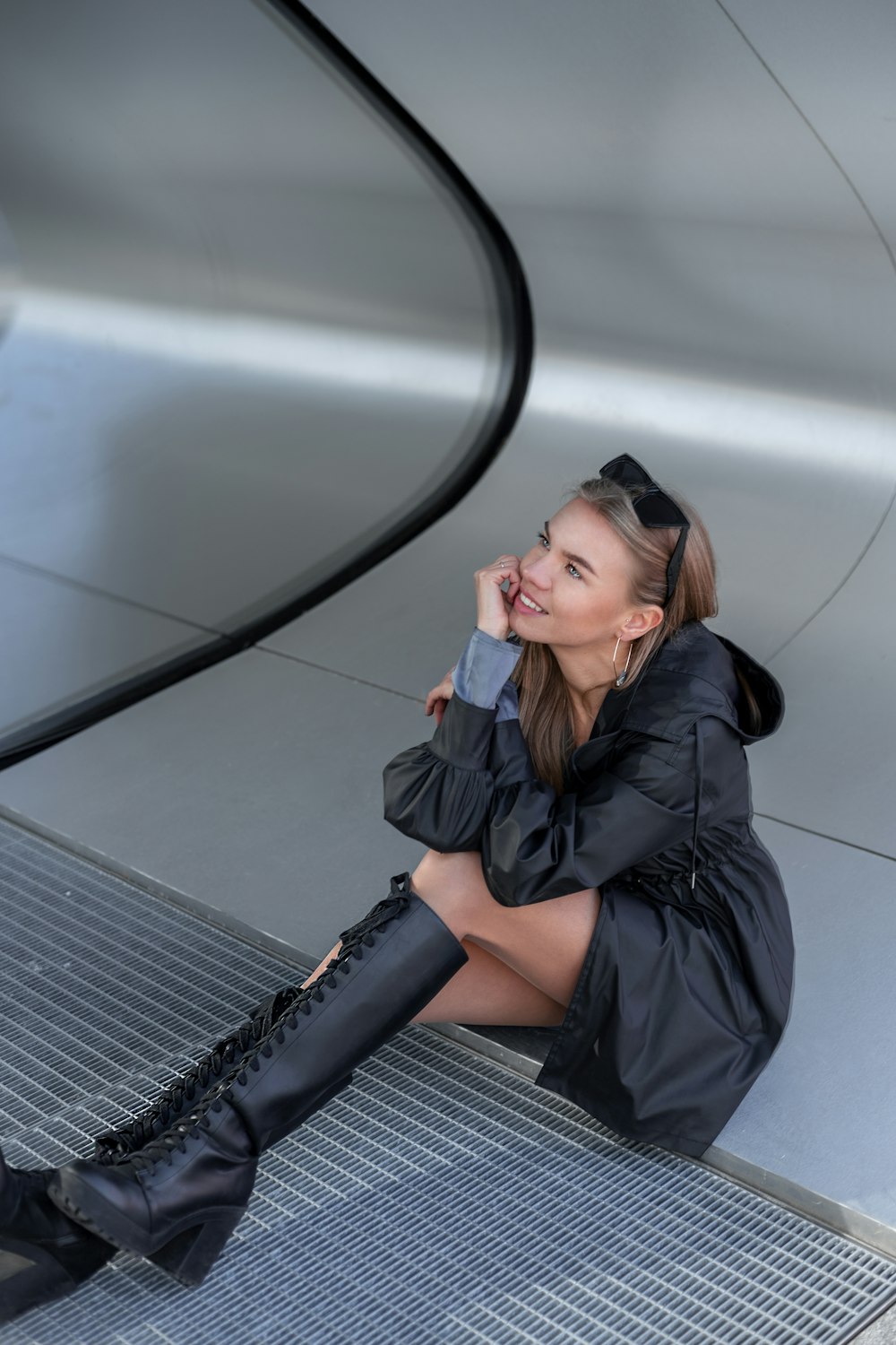 a woman sitting on the ground talking on a cell phone
