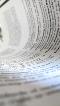 a close up of a book with a pen on top of it