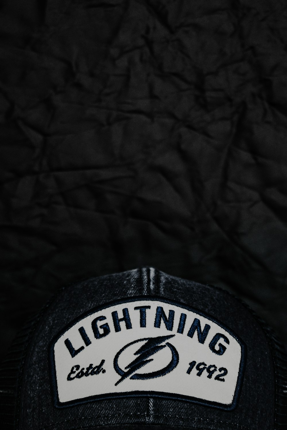 a black hat with a lightning patch on it