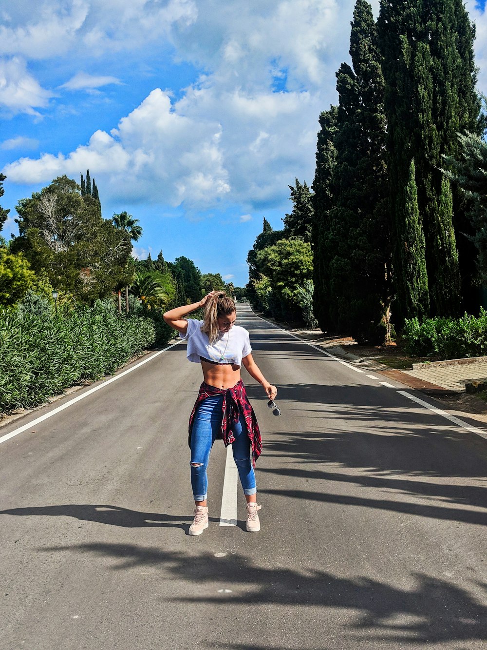 a woman standing on the side of a road