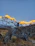 A hiker standing triumphantly at Mount Toubkal's snowy summit under a clear blue sky.