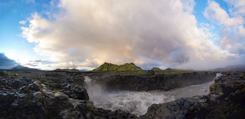 a large waterfall with a mountain in the background