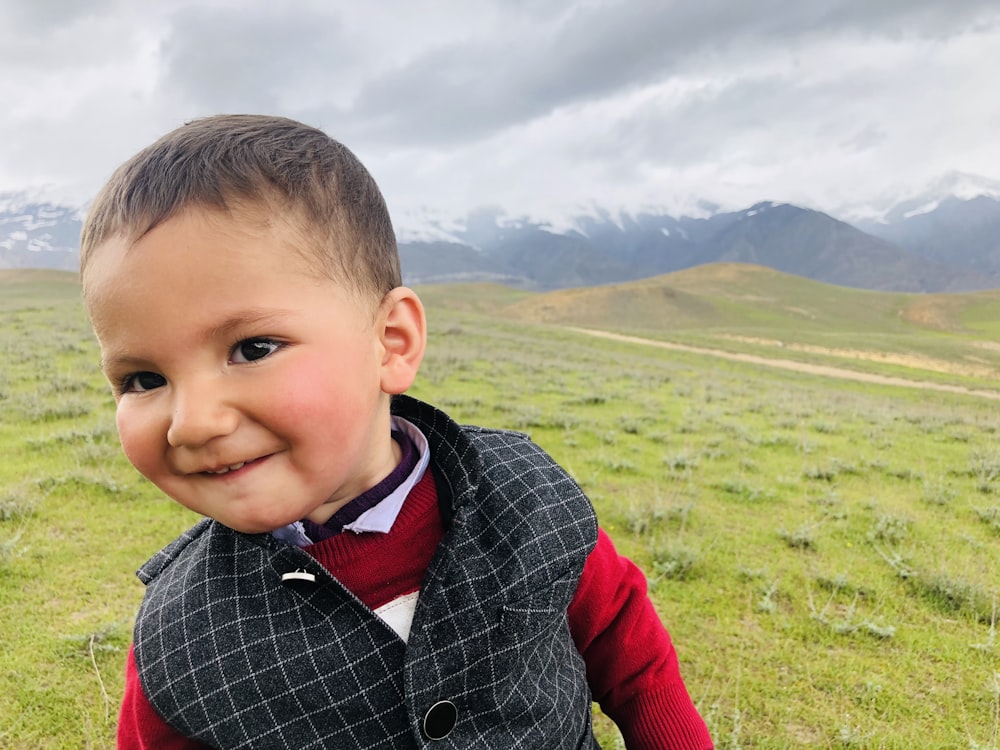 a little boy that is standing in the grass