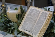 A book-based sculpture displayed on a wooden pedestal with soft lighting.