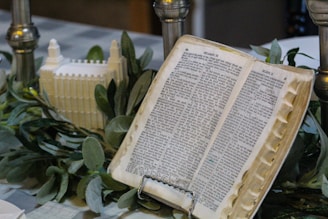 A book-based sculpture displayed on a wooden pedestal with soft lighting.