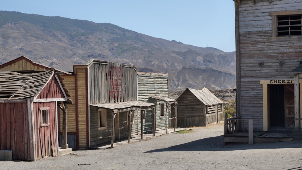 a row of wooden buildings sitting next to a mountain