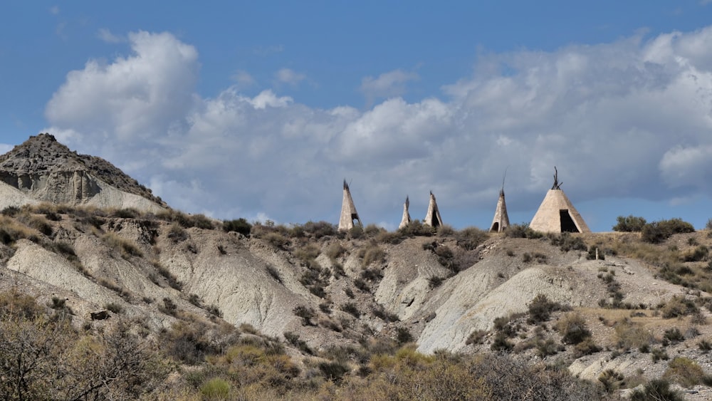 a group of teepee houses sitting on top of a hill