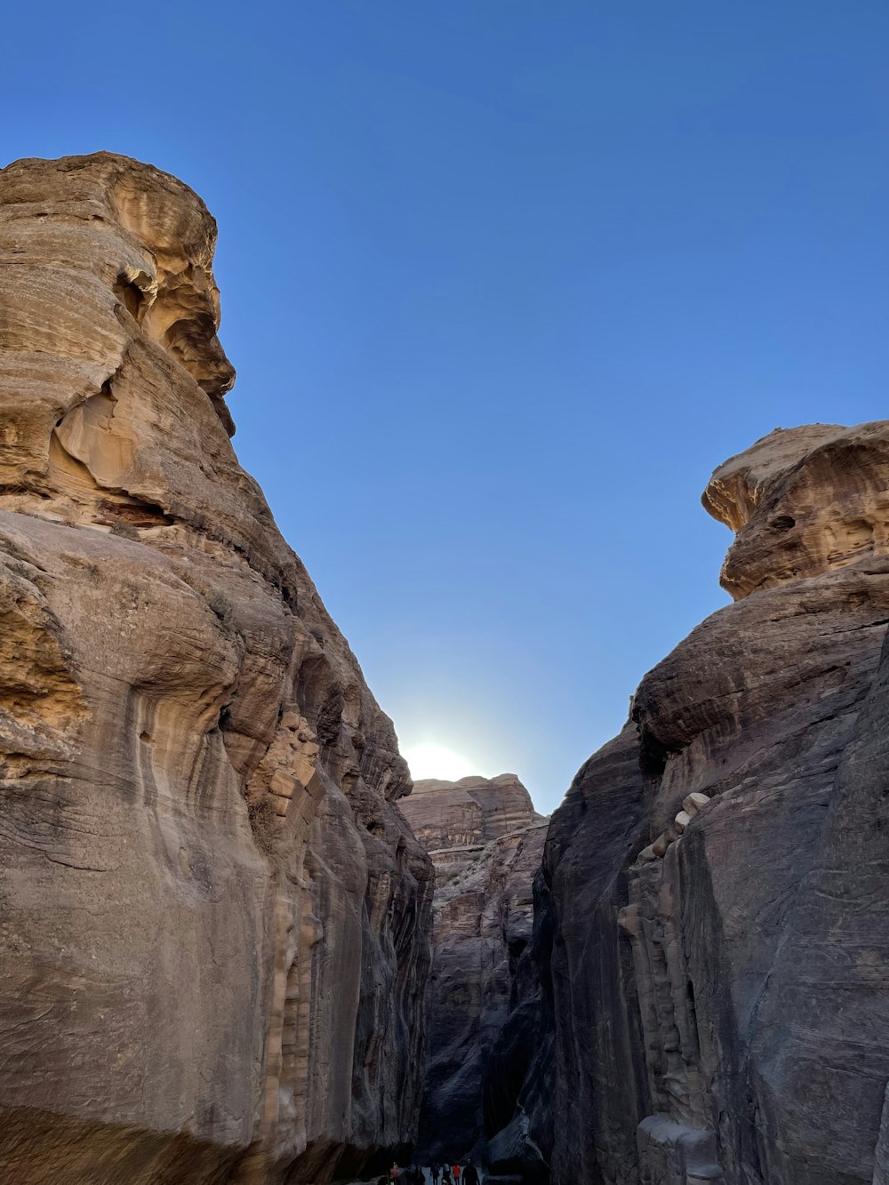 a group of people walking through a narrow canyon