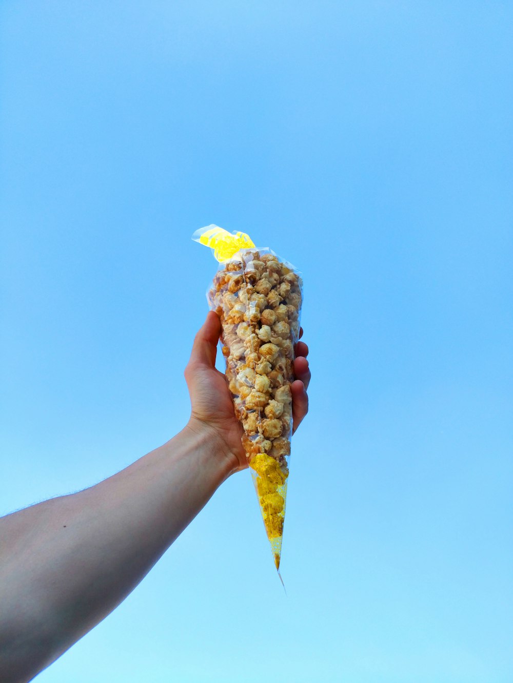 a person holding a corn on the cob in their hand