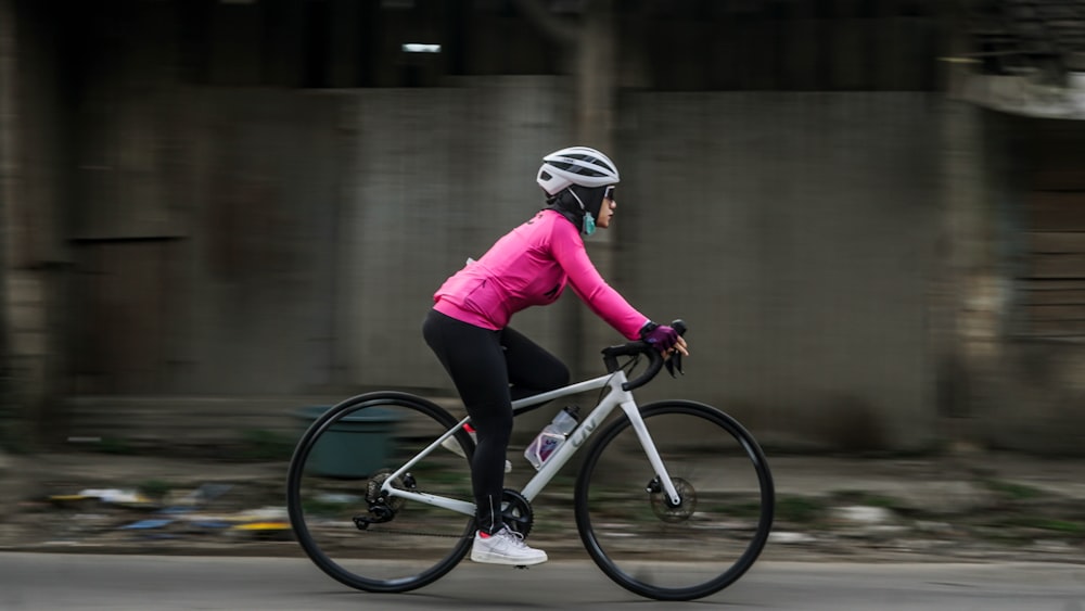 a woman riding a bike down a street