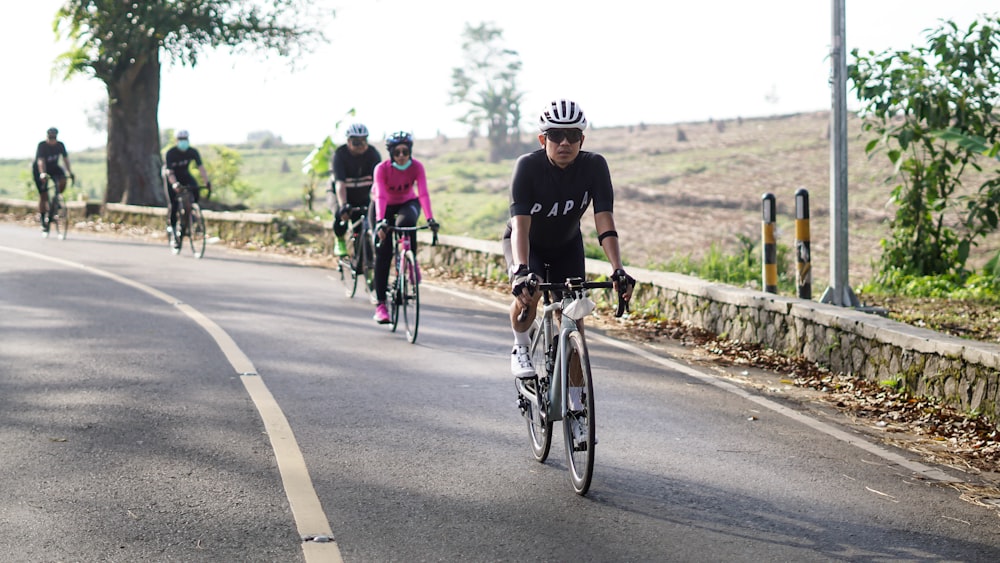 a group of people riding bikes down a road