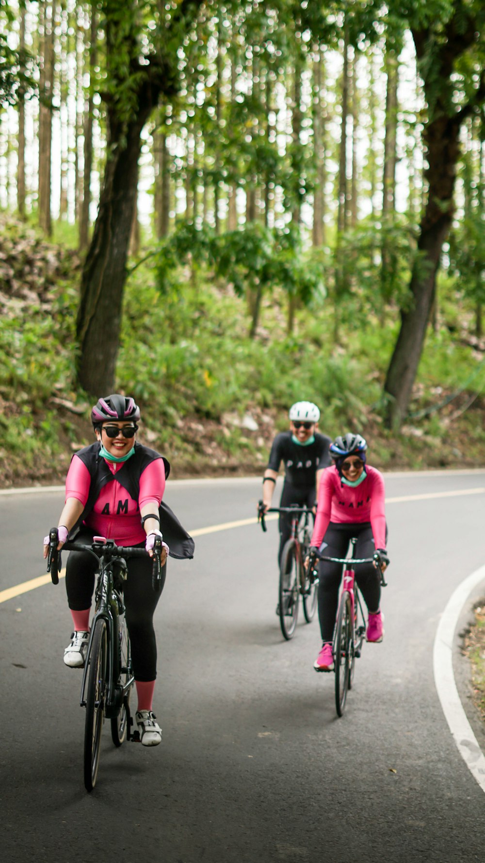 a group of people riding bikes down a curvy road