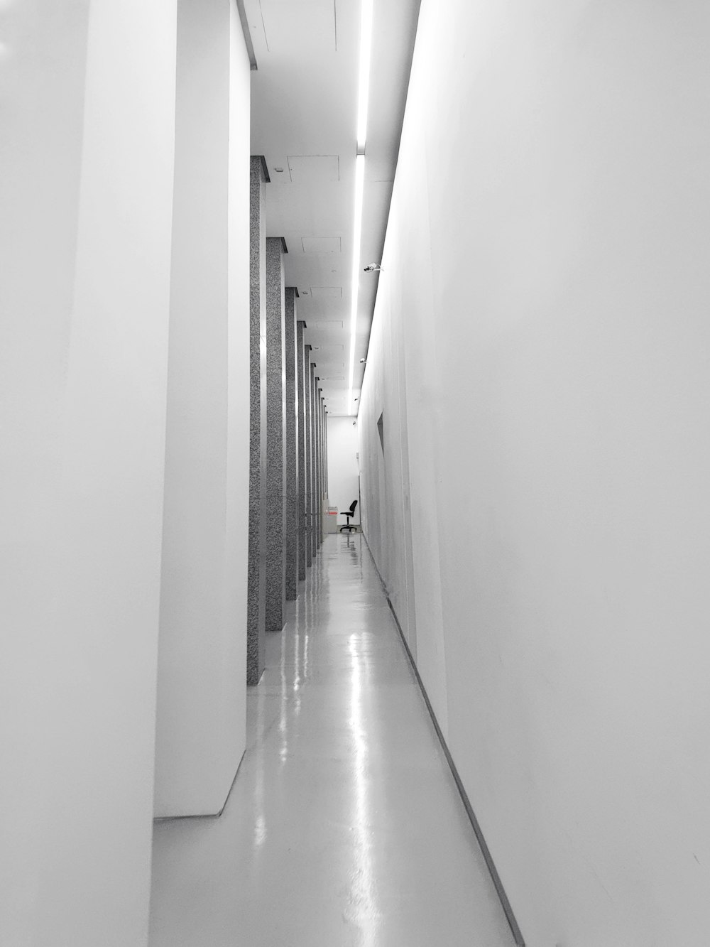 a black and white photo of a long hallway