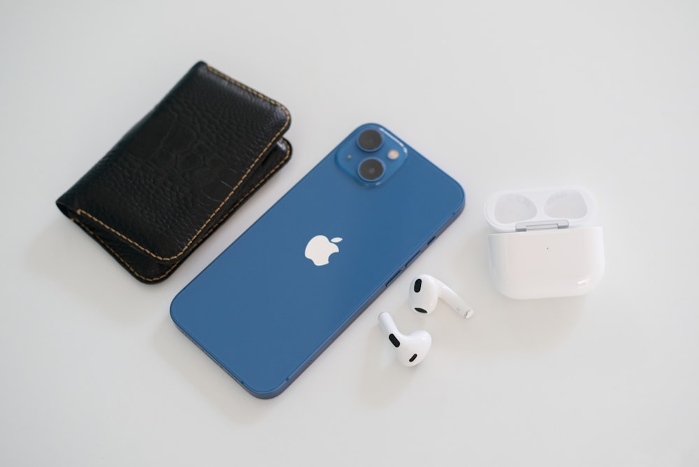 Un iPhone, auricolari e portafoglio su un tavolo