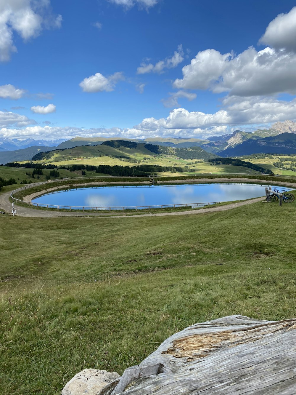 a large body of water surrounded by a lush green field