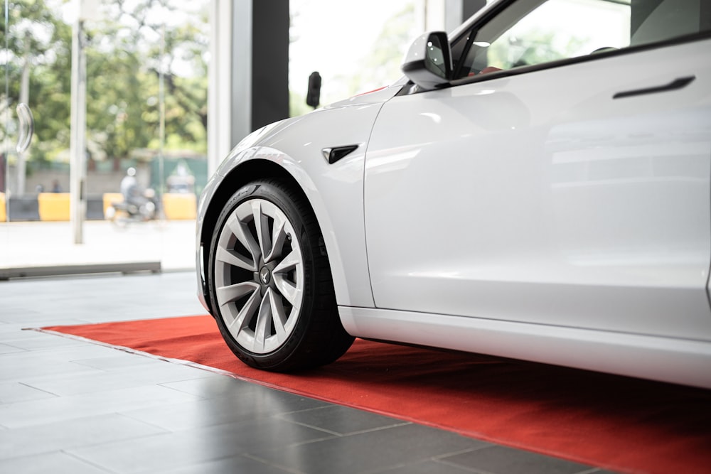 a white car is parked on a red carpet