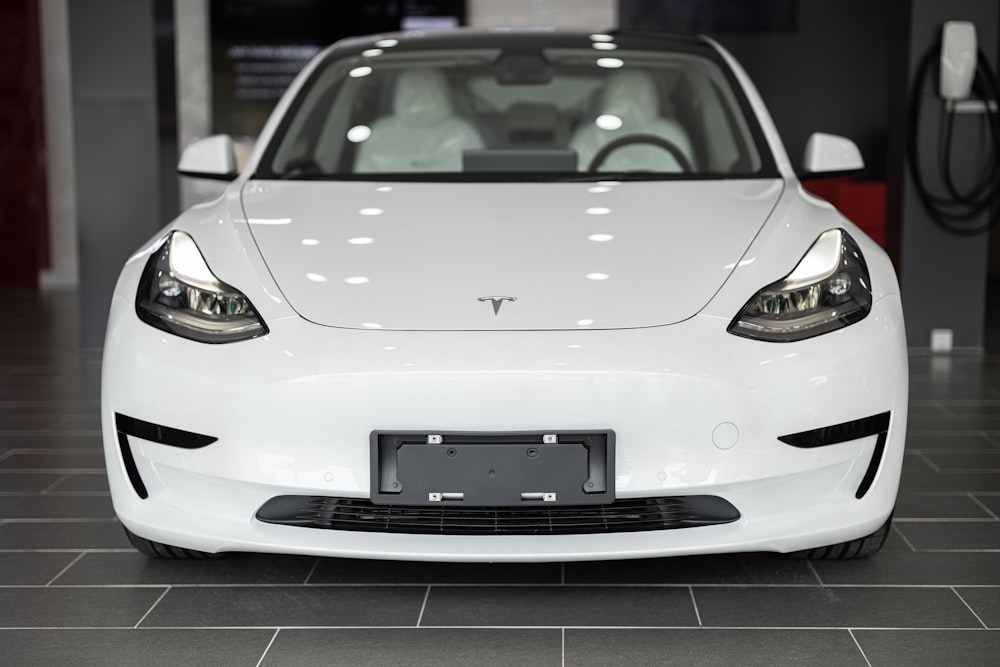 a white car is parked in a showroom