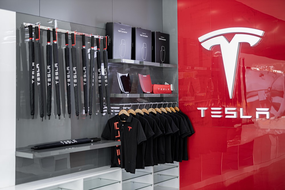 a store with a red wall and a tesla logo on the wall