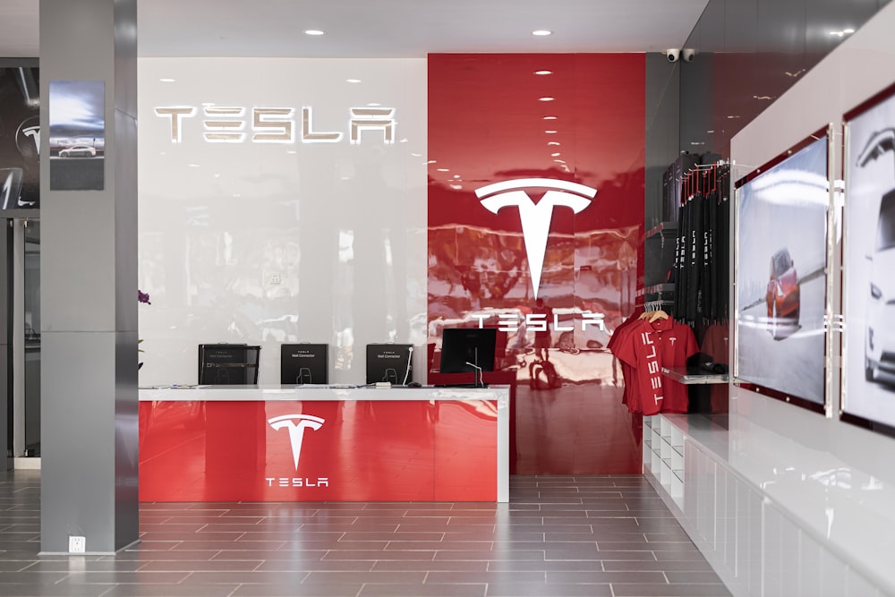 a tesla store with a red and white wall