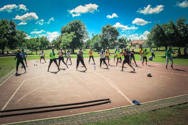A vibrant group of people playing basketball and practicing yoga together outdoors.