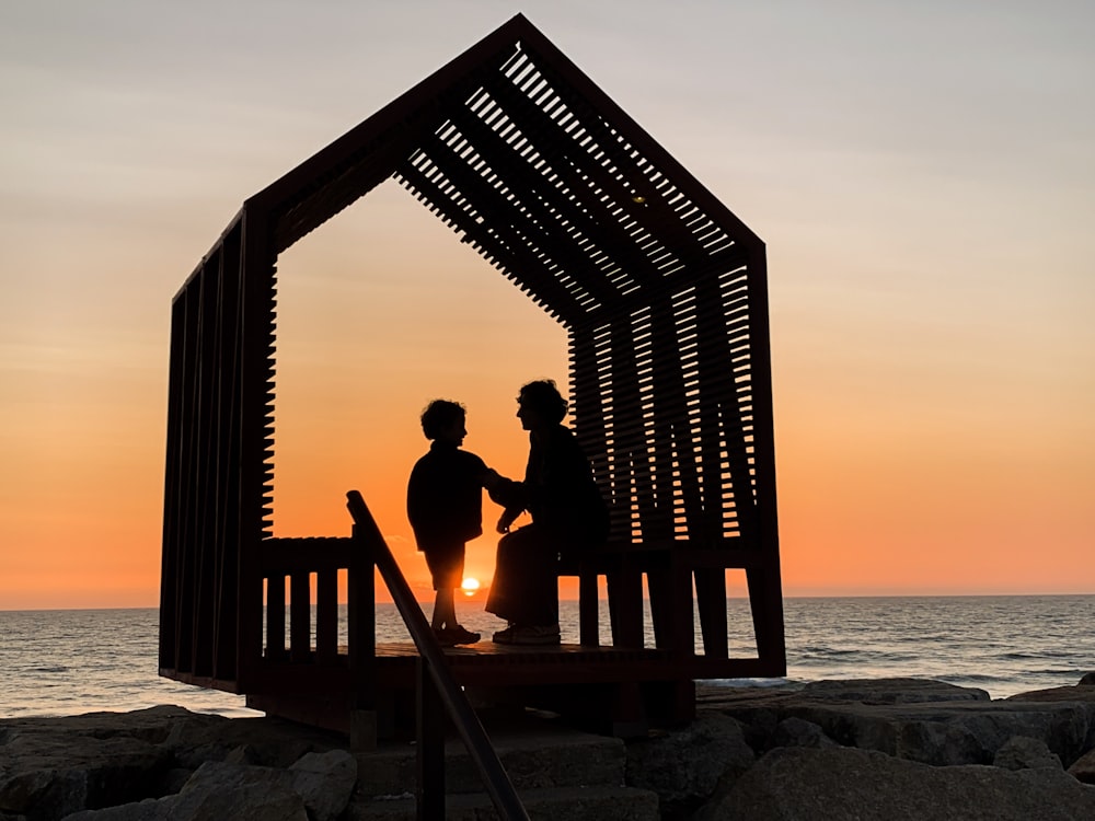 a couple of people standing on top of a wooden structure