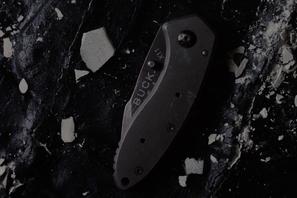 a knife laying on top of a black surface