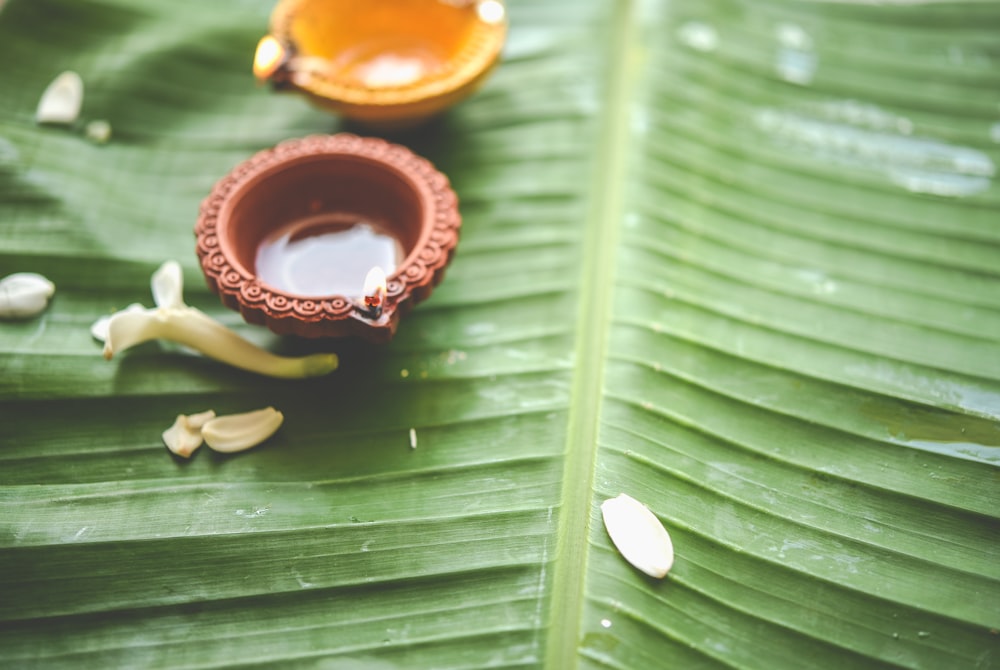 a close up of a banana leaf with a bowl on it