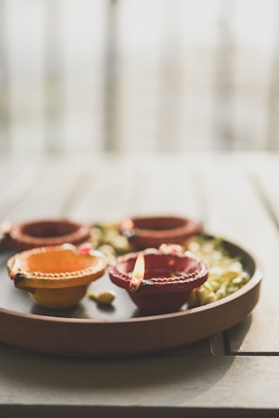 a plate with three bowls and a candle on it
