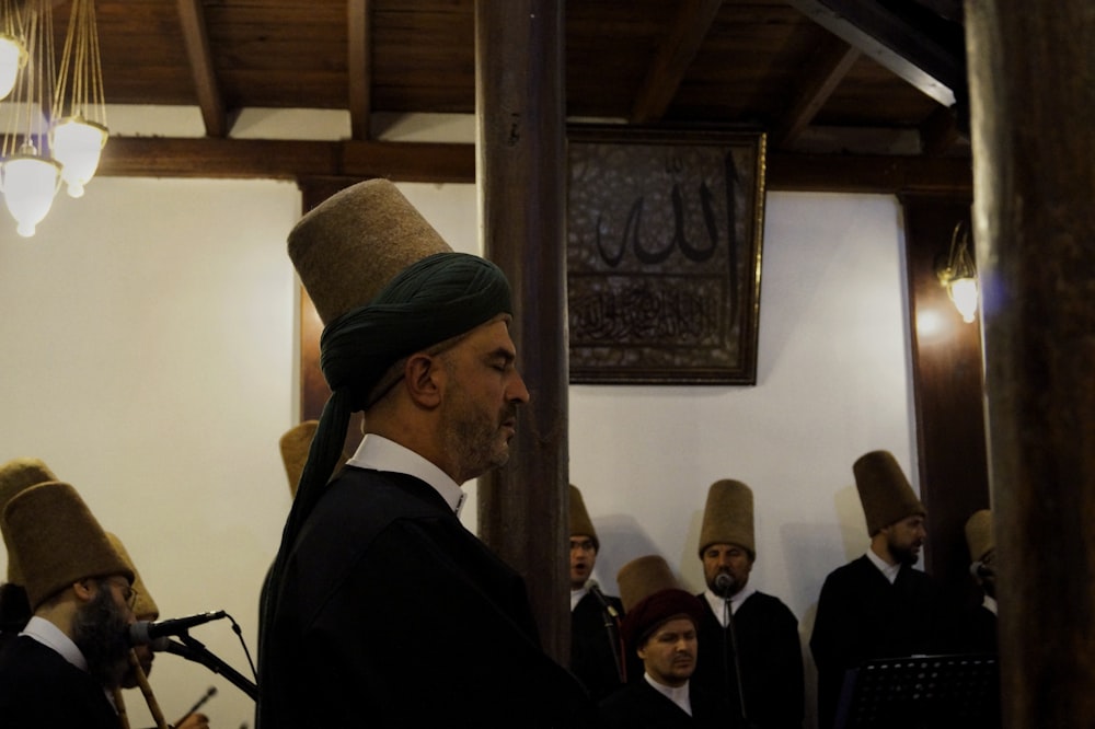 Un hombre con turbante parado frente a un grupo de otros hombres