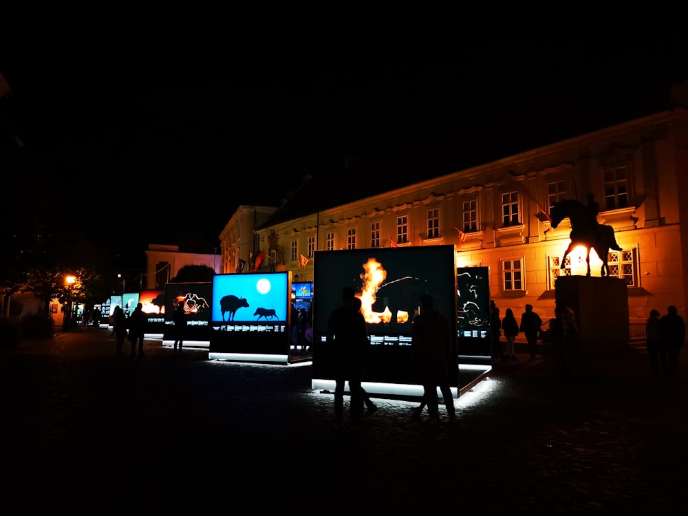 a group of people standing in front of a building at night