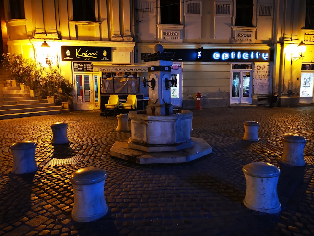 a fountain in the middle of a cobblestone street