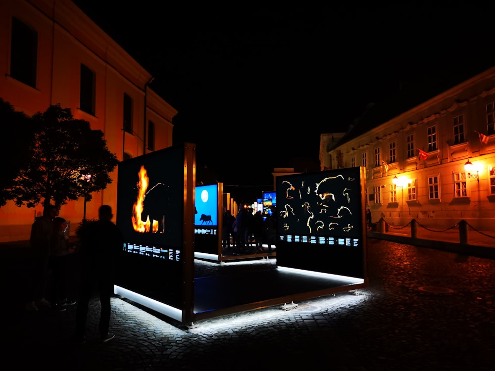 a group of people standing in front of a building at night