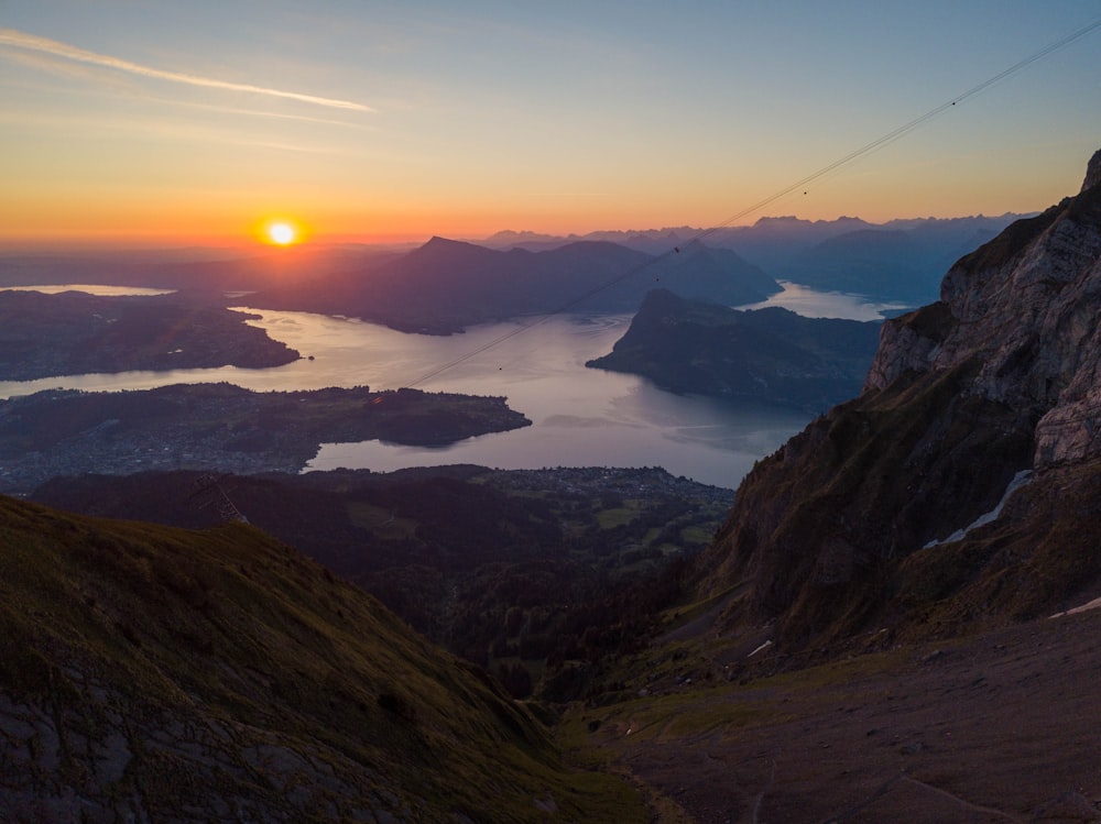 the sun is setting over a mountain range