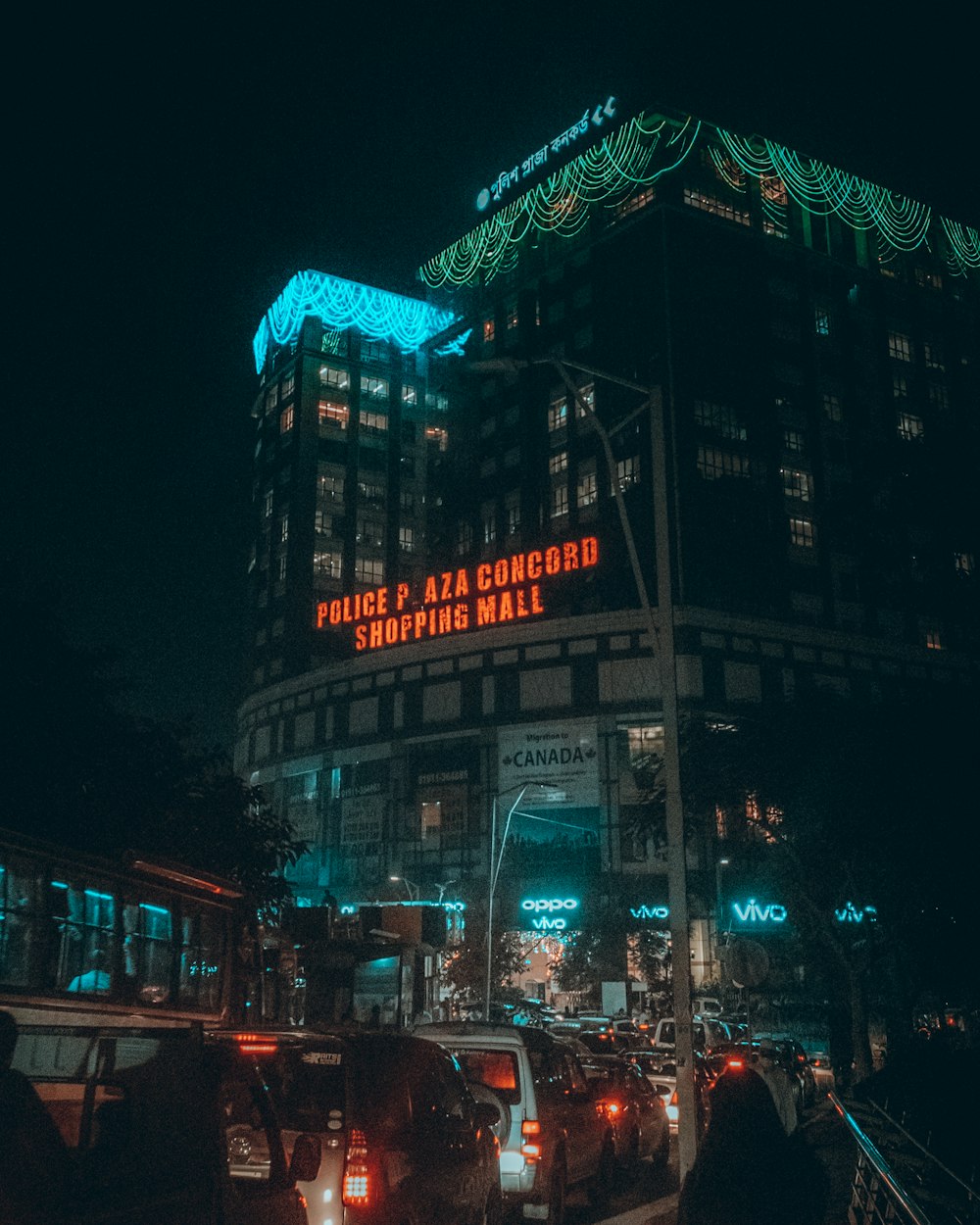 a busy city street at night with a building lit up