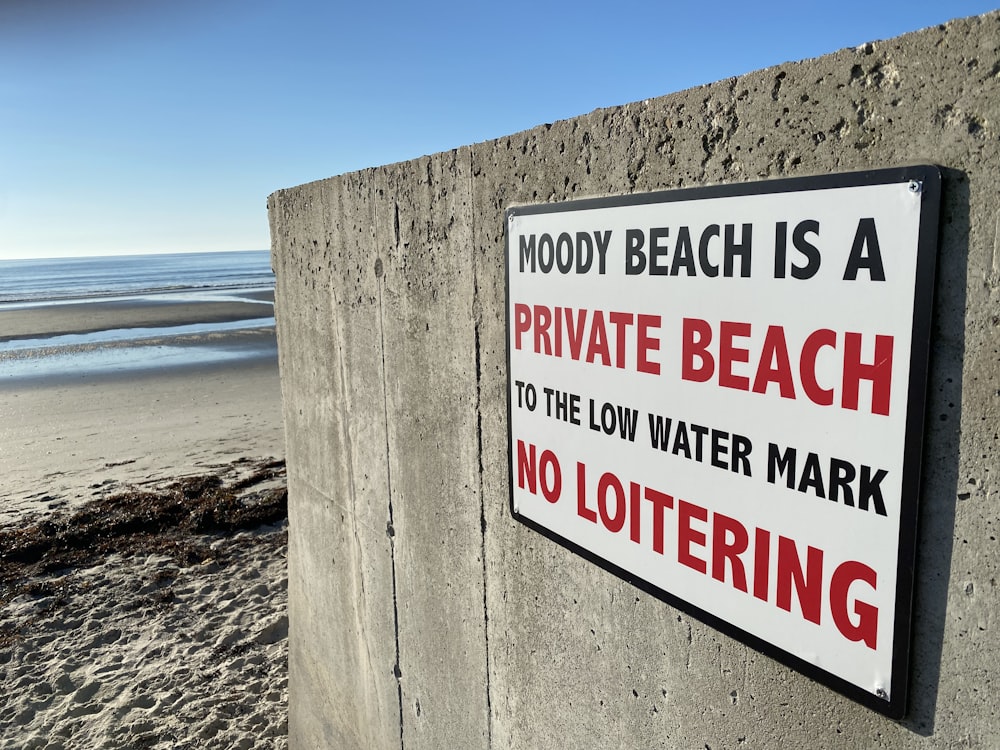 a sign on a concrete wall on a beach