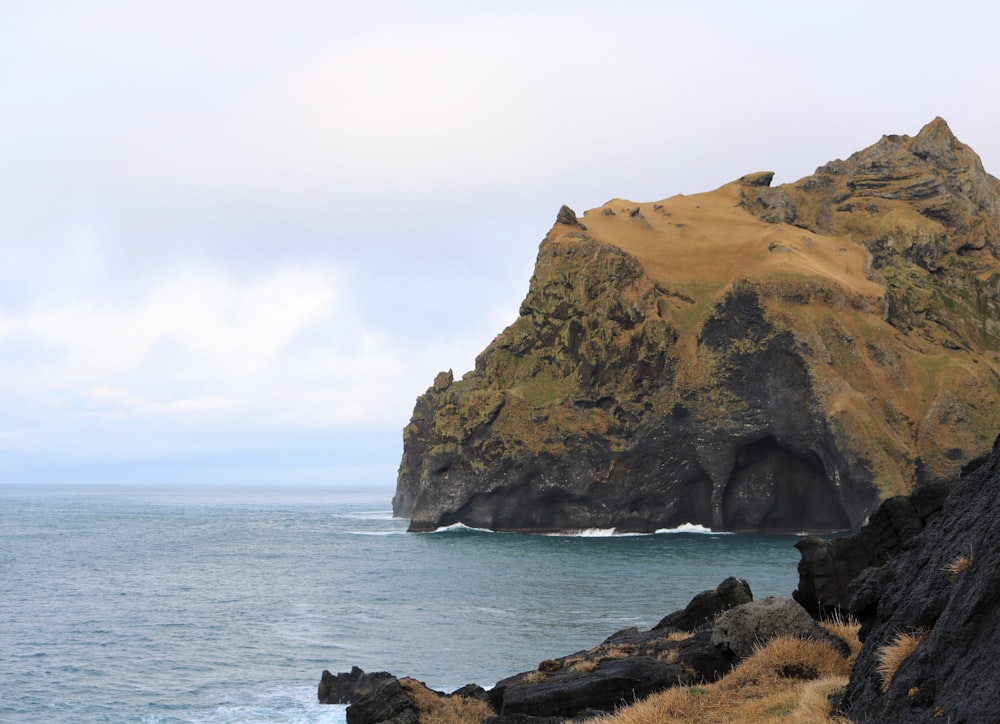 a large rock outcropping next to a body of water