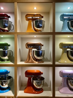 Display of colorful mixers and grinders neatly arranged on shelves.