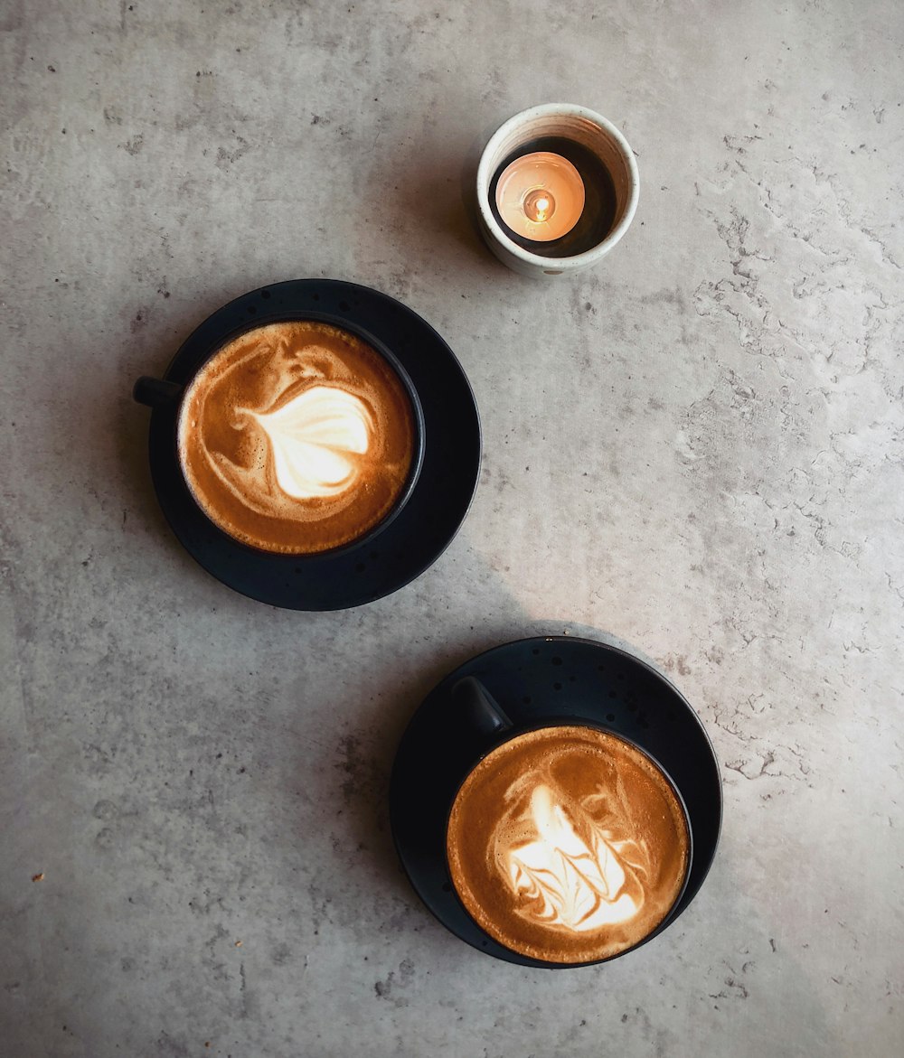 a couple of cups of coffee sitting on top of a table