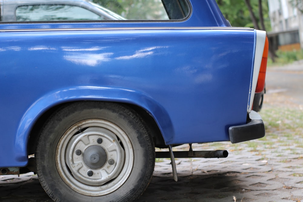 a blue pick up truck parked on a cobblestone road