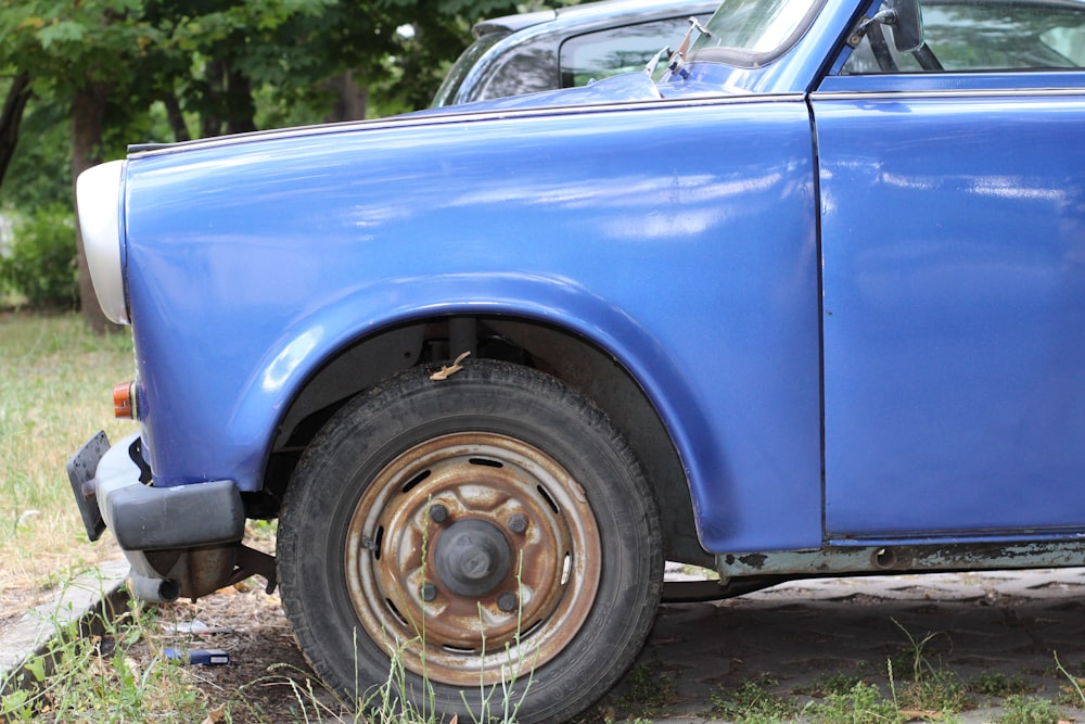 a blue car parked on the side of a road