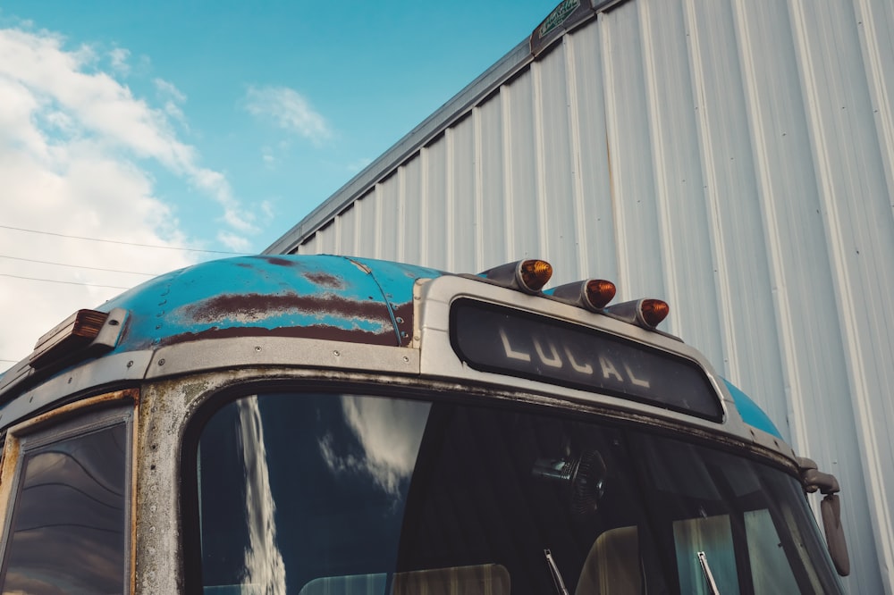 an old blue bus parked in front of a building