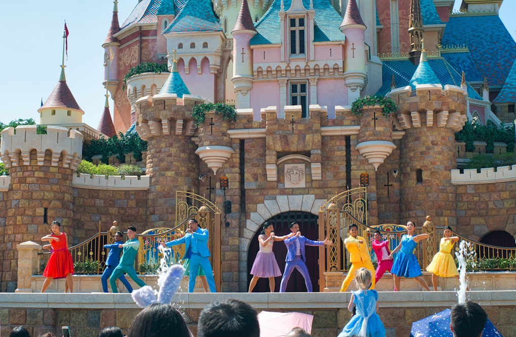 a group of people standing on top of a stage in front of a castle