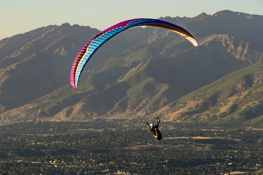 a person is parasailing in front of a mountain range