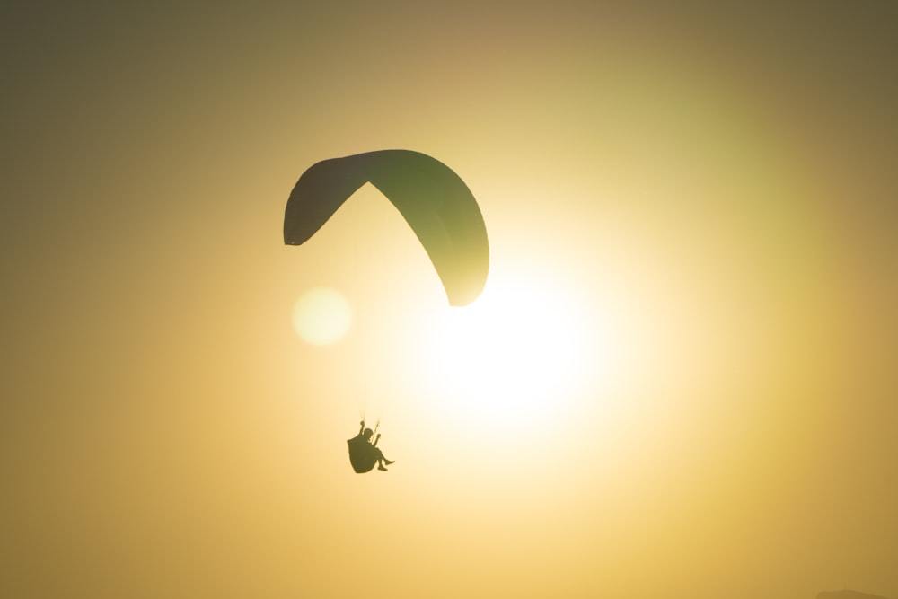 a paraglider is in the air at sunset