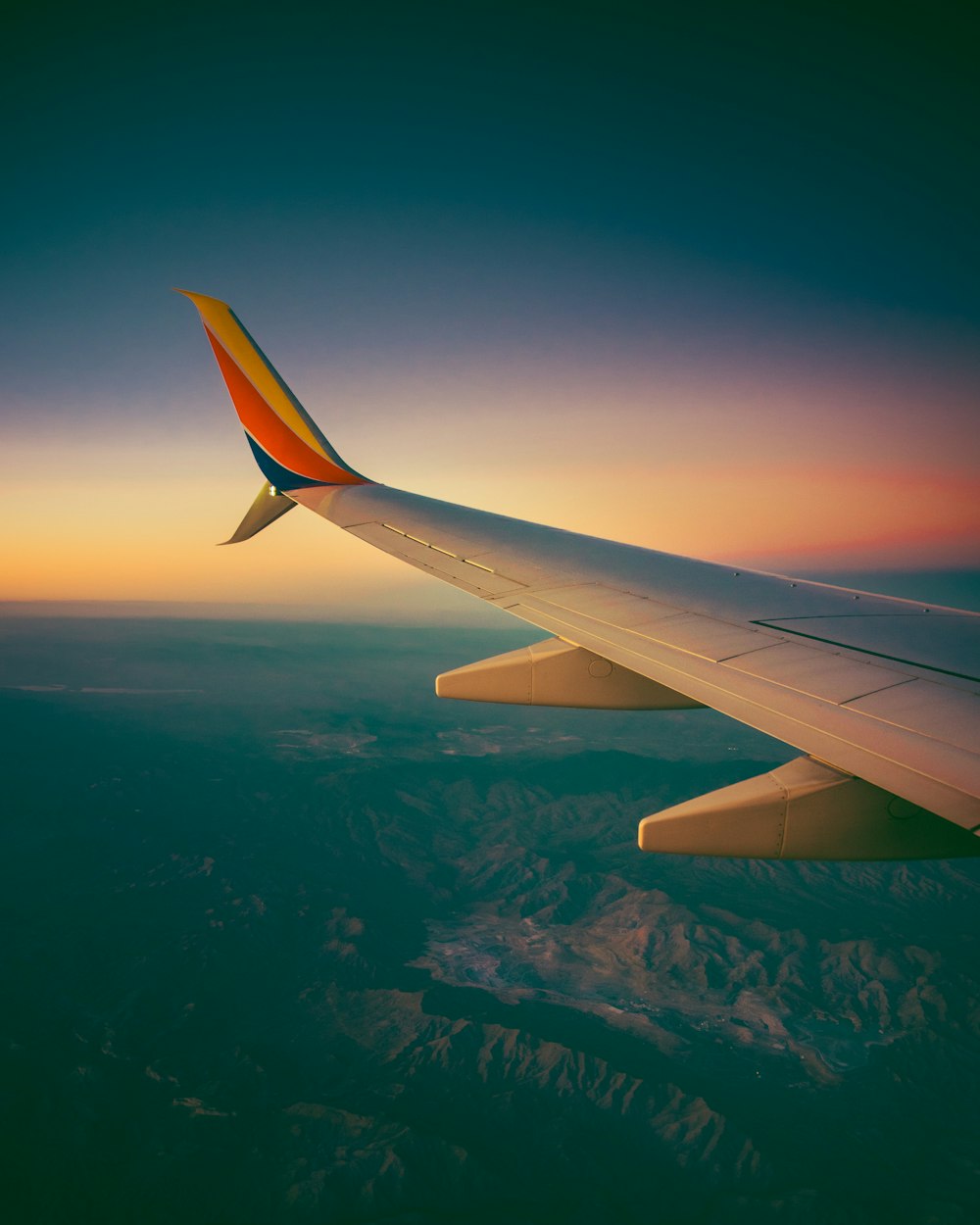 Blick auf den Flügel eines Flugzeugs bei Sonnenuntergang